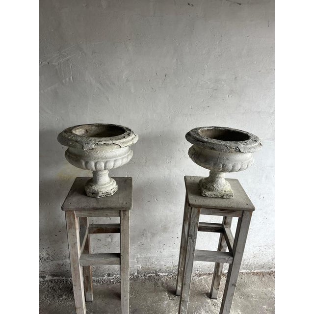 A beautiful pair of antique cast stone garden urns with a heavily weathered patina and classical decorative detailing....