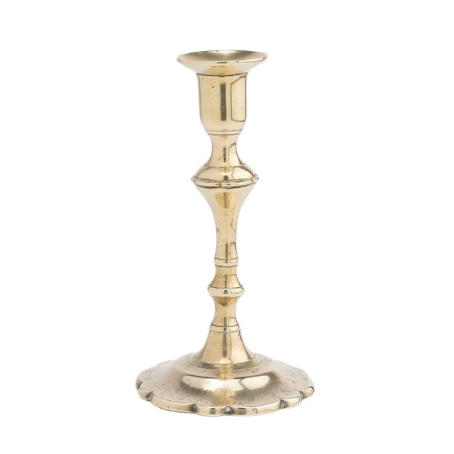 A rare miniature form of seam cast brass Queen Anne petal base candlestick with urn form candle cup. The candlestick has...