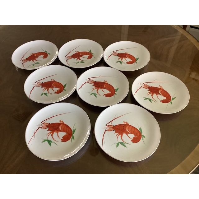 These vintage decorative plates include a red lobster design on a white background. The plates also have a gold rim. This...