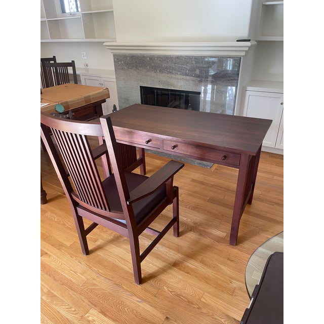 An authentic Stickley Mission Collection writing desk paired with its matching Stickley armchair, both bearing the...