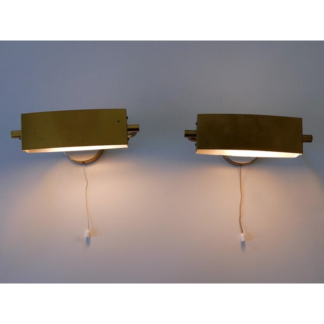 Set of two elegant mid-century modern wall lights / sconces with rotating shades. Down and up lighter. Designed and...