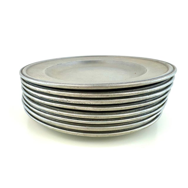 Crafted by Carron of Freeport, Pennsylvania, this vintage set of eight solid pewter salad plates embodies the understated...