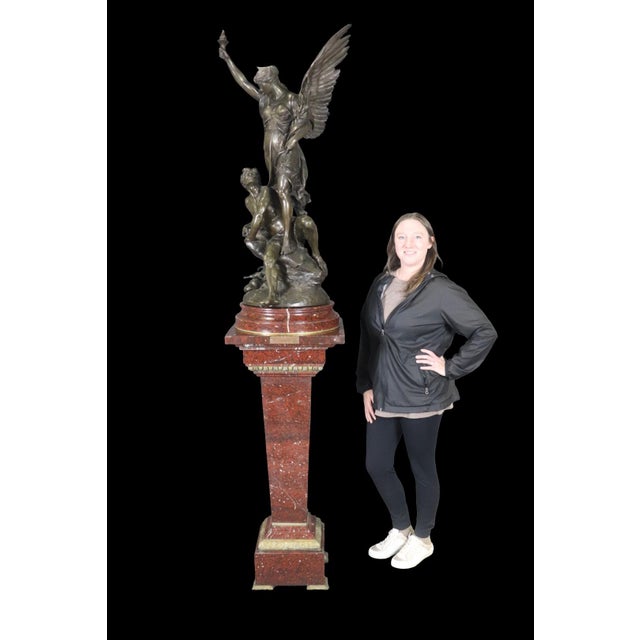 This impressive Rouge marble pedestal surmounted by a monumental bronze sculpture by Émile Louis Picault (1833–1915) is a...