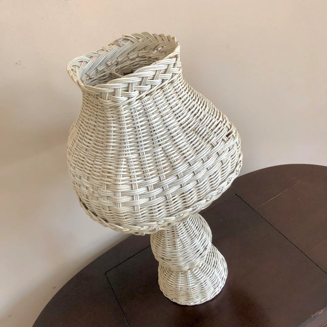 A vintage white painted wicker table lamp and shade.