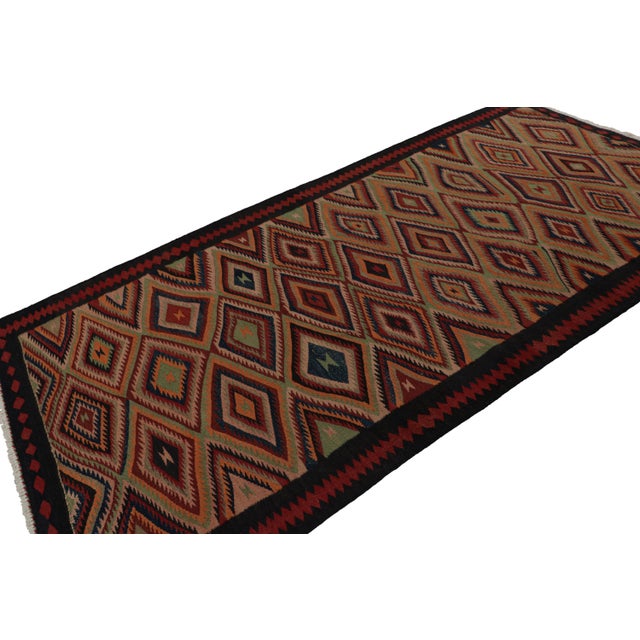 Handwoven in wool, circa 1950-1960, originating from Afghanistan, this 5x10 Afghan tribal kilim with graphic serrated...
