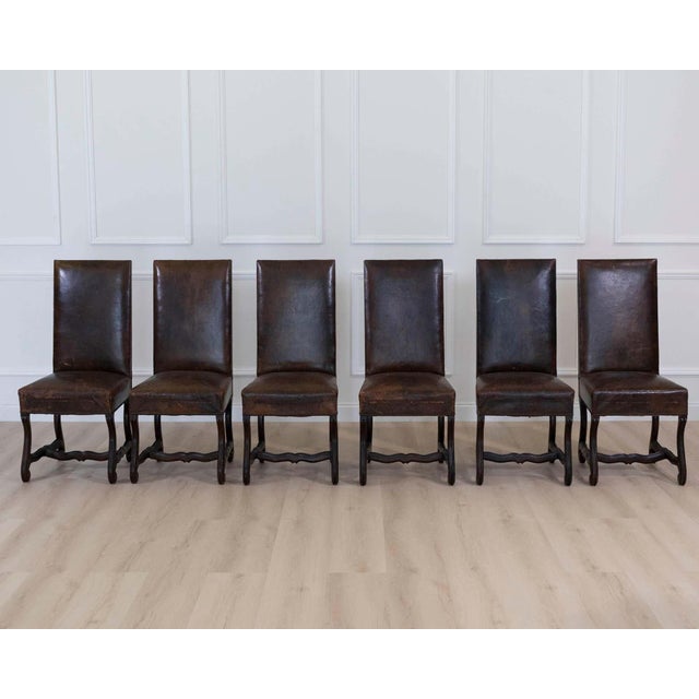 An exceptional set of six 19th century Spanish dining chairs featuring richly aged leather upholstery and beautifully...