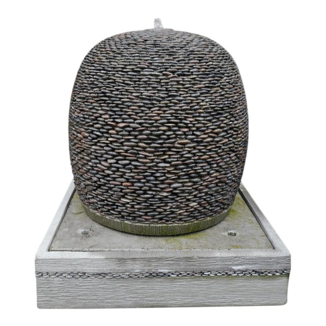 Pebble ball fountain. Rounded river stone framed to a sphere that sits on top of a matching base / reservoir. Water comes...