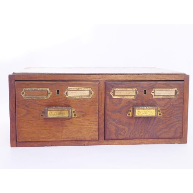 An antique wooden oak card catalogue with its original brass handles. The file organiser has two drawers to store your...