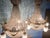 A magnificent pair of vintage French Louis XVI-style gilt bronze deer chandeliers, designed with sculptural deer head...