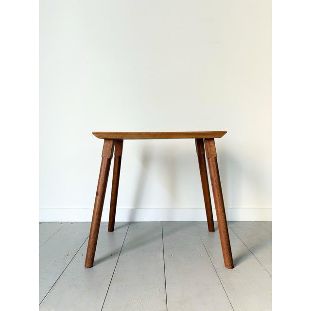 A simple 20th century cotswold school wooden side table or coffee table with chamfered leg detail, in a useful and...