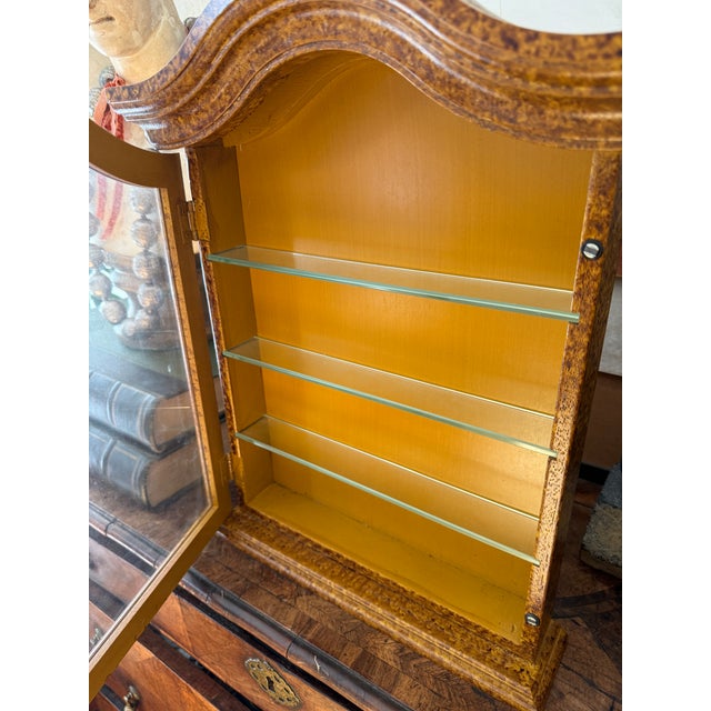 This elegant vintage hanging wall curio cabinet is marked Made in Italy on the back and features a classic, softly arched...