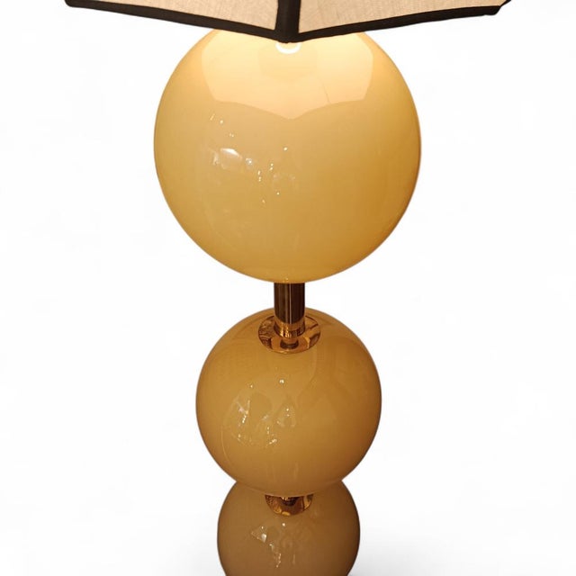 Stunning Italian floor lamp featuring large Murano glass spheres. A cylindrical shaft of the same metal rises from a...