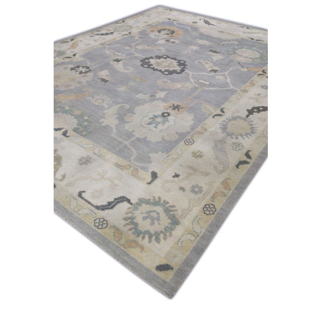 This modern Turkish Oushak rug is a stunning piece of art that has been handwoven using traditional techniques by skilled...