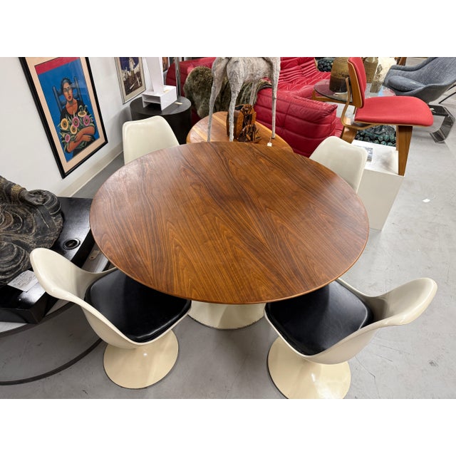 A beautiful and quite rare very early production Knoll Eero Saarinen Tulip table and chairs. The Walnut top table and...