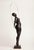 A contemporary figurative bronze of a standing woman with a skipping rope, the rope arching high overhead in a single...