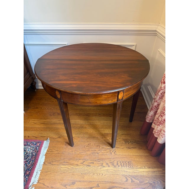 This George III mahogany game table exemplifies the refined elegance and craftsmanship of 18th-century British furniture...