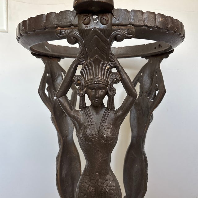 Striking and highly decorative antique cast-iron pedestal stand featuring elaborate female caryatid figures with raised...