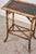 This 19th-century rectangular bamboo side table features a black lacquered top, framed by bamboo trim. The legs are gently...