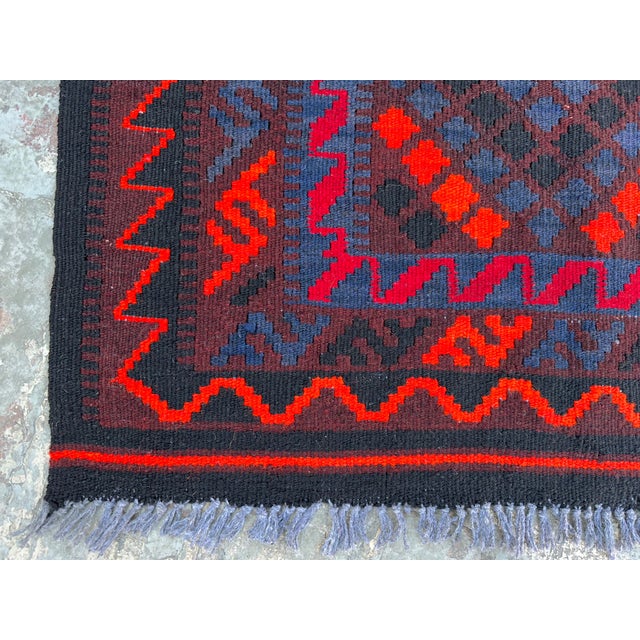 This vintage Afghan kilim rug, handmade in the 1990s in Maimana Village, Afghanistan, showcases a striking Turkmen tribal...