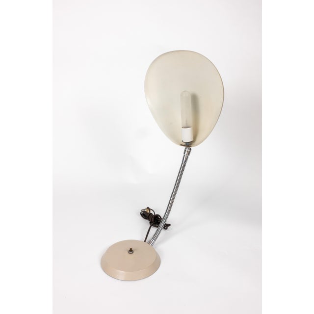 Cobra table lamp, designed by Greta Magnusson Grossman and made by Ralph O. Smith. A beige enameled shade shaped like a...