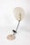 Cobra table lamp, designed by Greta Magnusson Grossman and made by Ralph O. Smith. A beige enameled shade shaped like a...