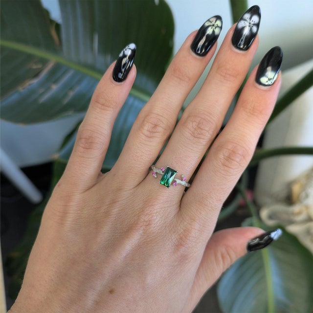 A natural indicolite tourmaline glows in cool blue-green at the center of this baguette ring, flanked by delicate pink...