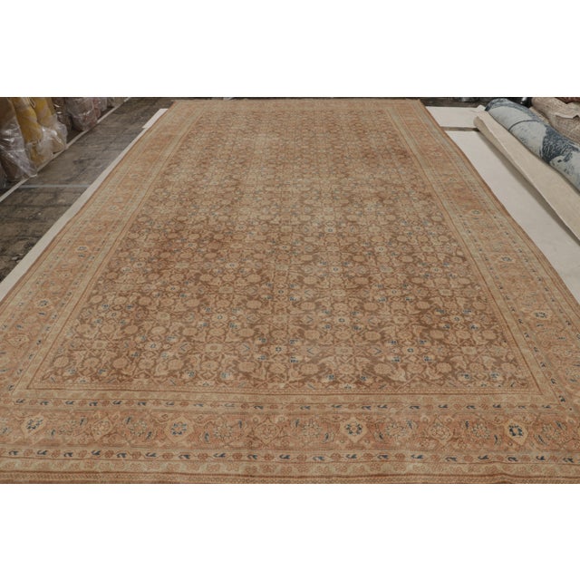 Hand knotted in wool circa 1950-1960, this vintage 10x16 Tabriz rug exemplifies Persian rugs of the period, relishing an...