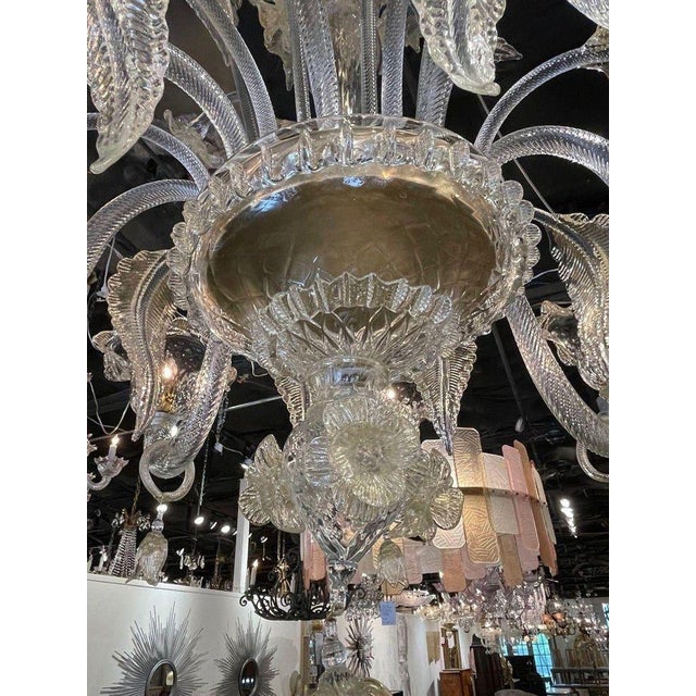 This Venetian style Murano glass chandelier features intricate designs of leaves and flowers, adding a touch of elegance...