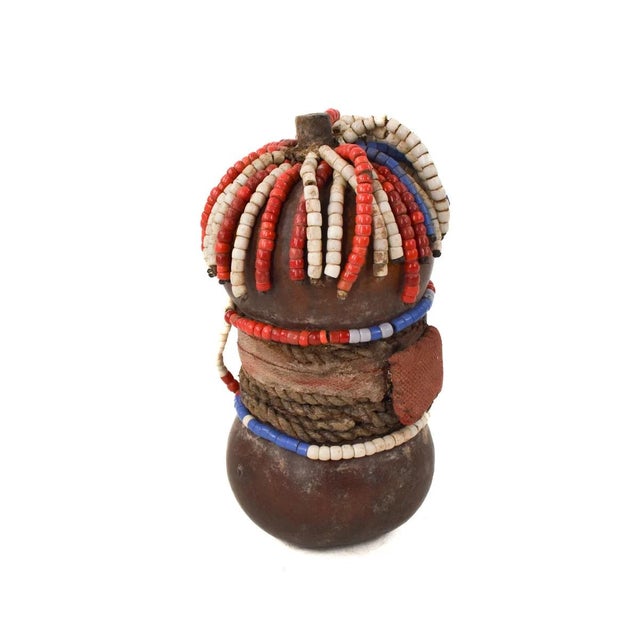 The Nyamwezi Beaded Fertility Doll Gourd with Shells from Tanzania is a stunning representation of fertility and...