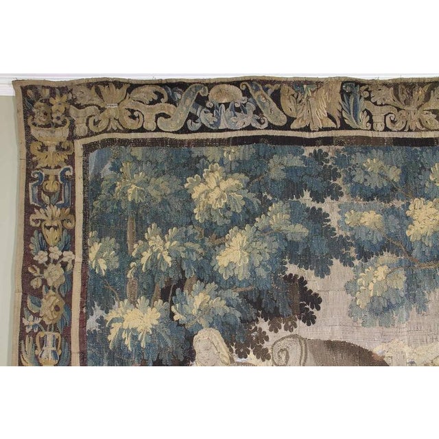 Rectangular with leaf, flower and vase border, the scene depicting a man baking bread in an oven with a woman standing by...