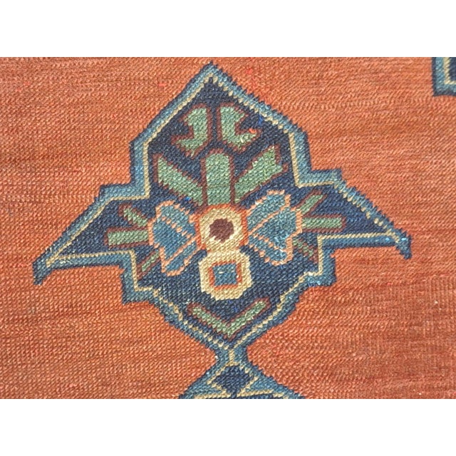 Vintage Anatolian hand-knotted wool rug featuring a bold geometric medallion on a warm terracotta field, framed by an...
