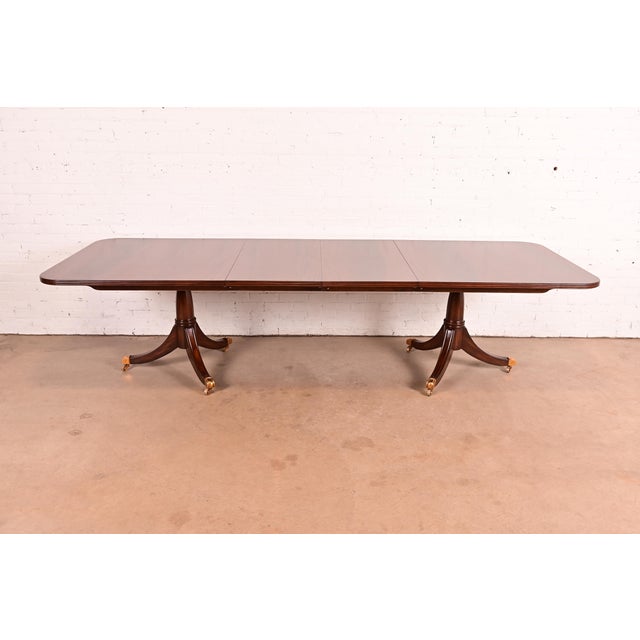An exceptional Georgian or Regency style double pedestal extension dining table By Maitland Smith Late 20th Century...