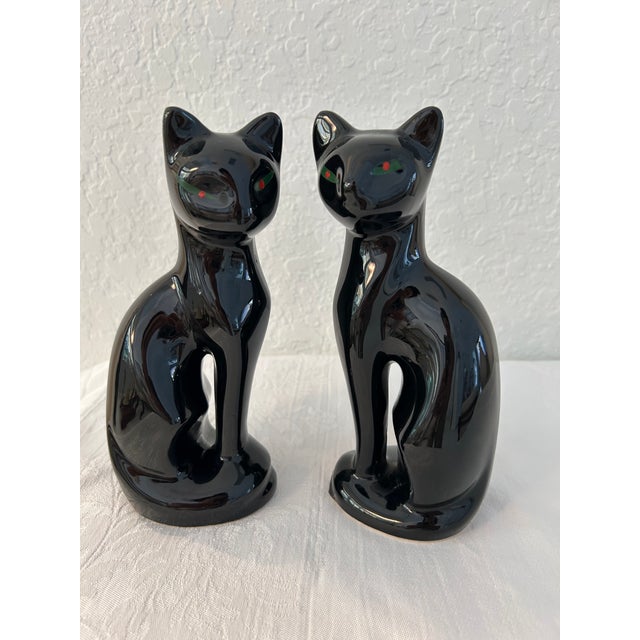 Mid-Century pair of ceramic sitting black Siamese cat figurines in a high gloss finish.