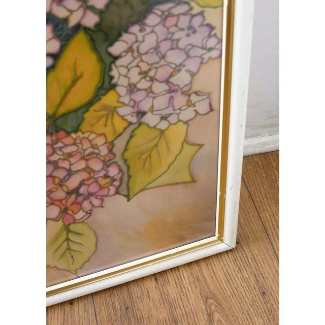 Large framed painting on silk; illustration depicting a garden, with hydrangeas, a white rattan armchair, a balustrade and...