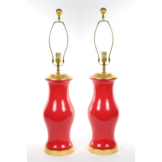 Pair of hurricane-shaped porcelain vases with salmon red glaze, mounted on round gilded pedestals with new barrel-shaped...