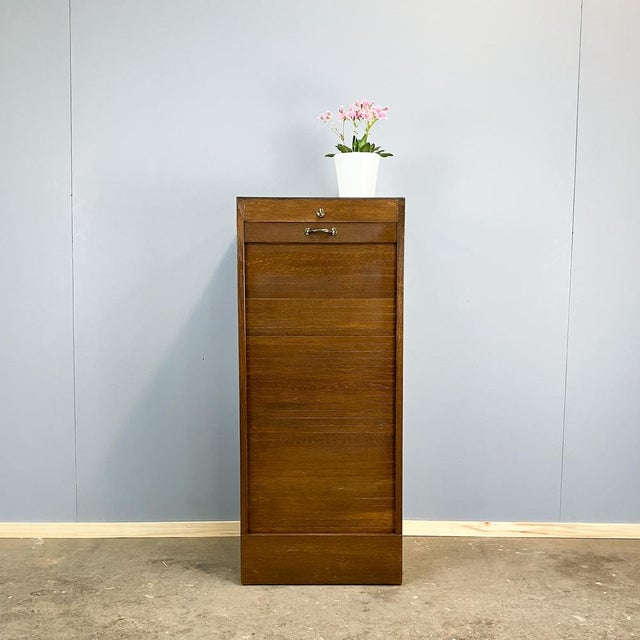 Nostalgic, cool, and practical to boot. This small roll-top cabinet is a true organizational wonder for your office. with...