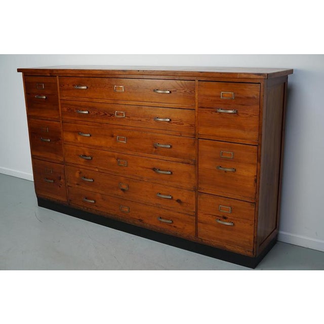 This apothecary / shop cabinet was produced during the 1930s in the Netherlands. It features 12 drawers with metal art...