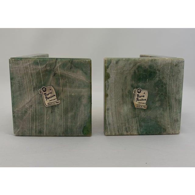 The bookends feature carved cream-colored elephant figures set against substantial green-veined stone uprights and bases....