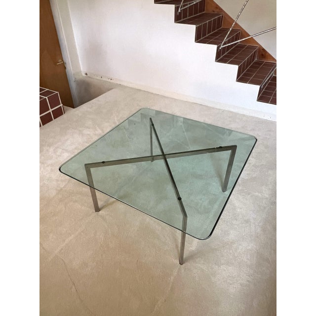 Mid-century modern glass coffee table inspired by the iconic modernist designs of Mies van der Rohe. The table features a...