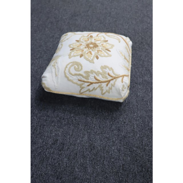 Decorative crewelwork pillow in neutral beige, brown and cream colors.