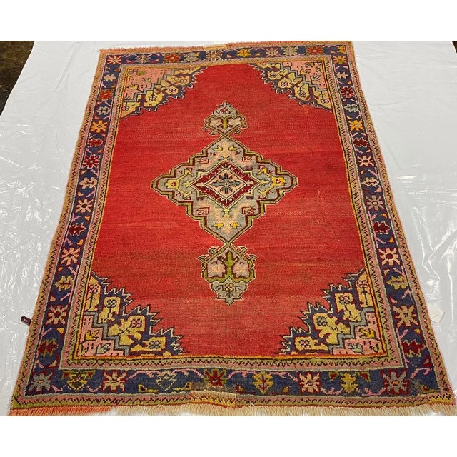 This traditional handwoven Vintage Turkish Oushak rug with an elegant red colored field features a very rare oval-shaped...