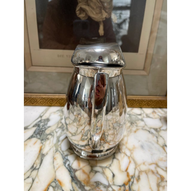 A beautiful pitcher in plated silver. This pitcher has a few imperfections: two small dents on one side and the lip is a...