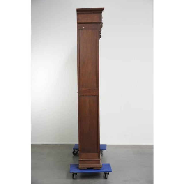 This charming antique Dutch bookcase from the early 20th century is made of oak and features beautiful details. The...