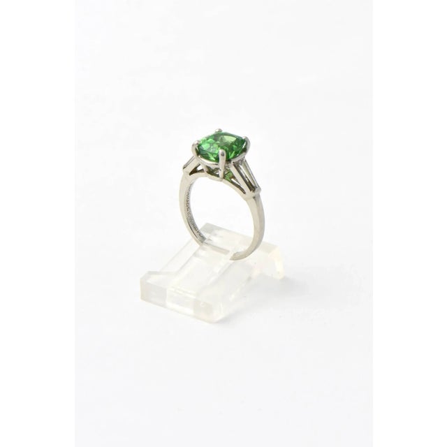 Stunning GIA certed natural Tsavorite Garnet mounted in a simple tapered baguette diamond and platinum mounting. The 2.78...