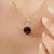 The Carat&Her Crimson Ember Pendant features a striking 4.93-carat trillion-cut garnet with a deep crimson hue and...