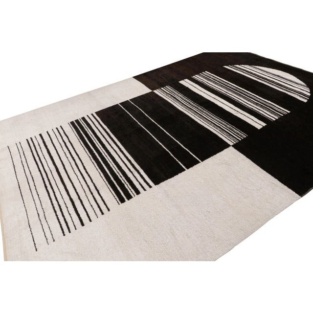 Hand knotted in wool, this 9x13 contemporary rug “Gateway to Heaven” features a design that plays abstract minimalist and...