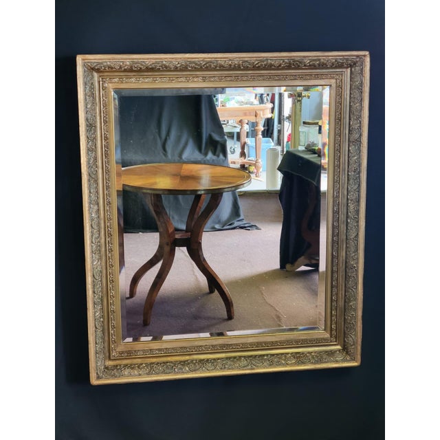 Beautiful antique 19th-century French Rococo Revival gilt wall mirror featuring an ornate floral and scrolling frame with...