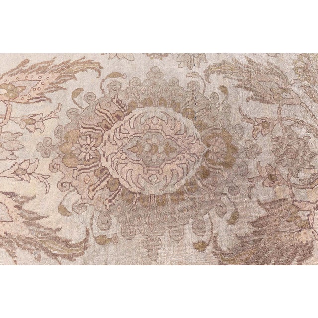 An Antique Persian Sultanabad Rug with a uniquely scaled floral and vine design that mirrors into an abstract medallion...