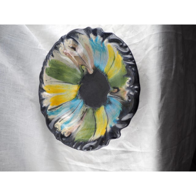 Fruit bowl with baroque shape and pastel colours (blue, green, yellow, pink), black background. This plate mix...