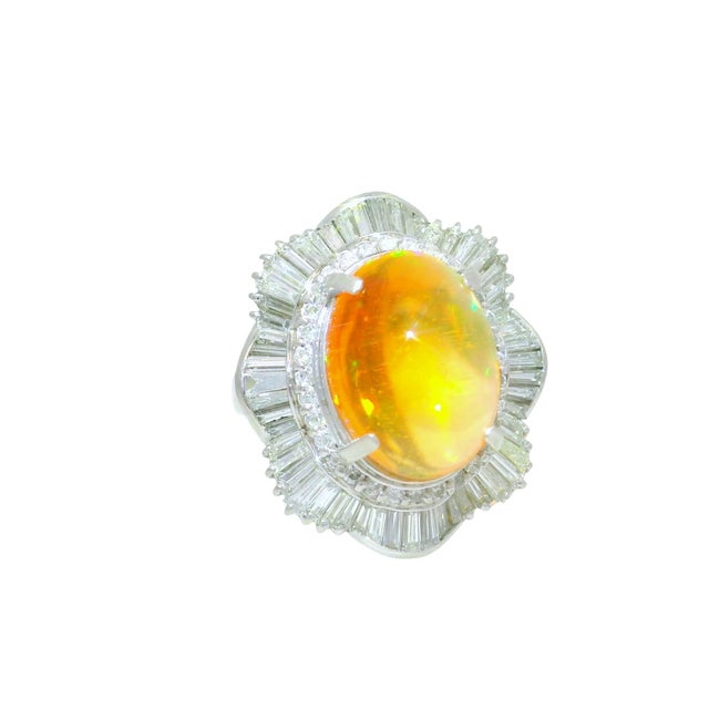 A striking platinum dome ring featuring a captivating fire opal at its center. The opal weighs 7.41 carats, showcasing a...